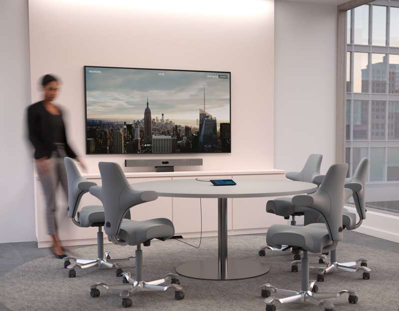 Modern conference room with a large screen display and ergonomic chairs for professional meetings.